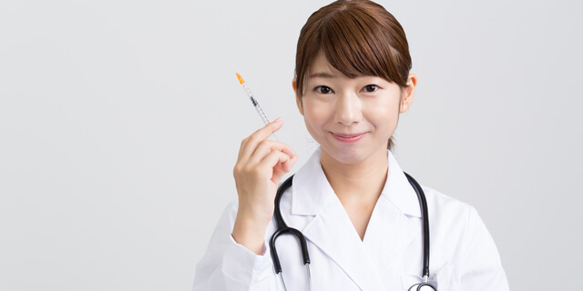 注射機を持つ女性